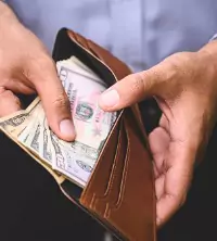 Man looking in wallet, worried about finances and getting anxiety