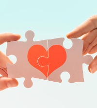 Two hands putting puzzle pieces of a heart together, representing a positive development in marriage counseling near you