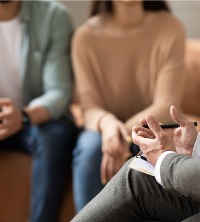 A couple sitting down with a therapist to discuss why they are not getting along