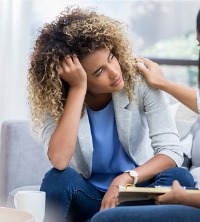 A woman suffering from stress, being consoled by her therapist during General Counseling Services in East Peoria IL