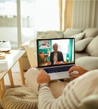 A man on the couch talking with his therapist on a computer during Telehealth Counseling in Dunlap IL