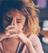 A woman struggling with stress at work, considering Burnout Treatment in East Peoria IL