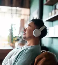 A man listening to music quietly and indulging in self care to improve his mental health