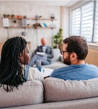 Partners on a couch talking with a therapist during Couples Therapy in Washington IL